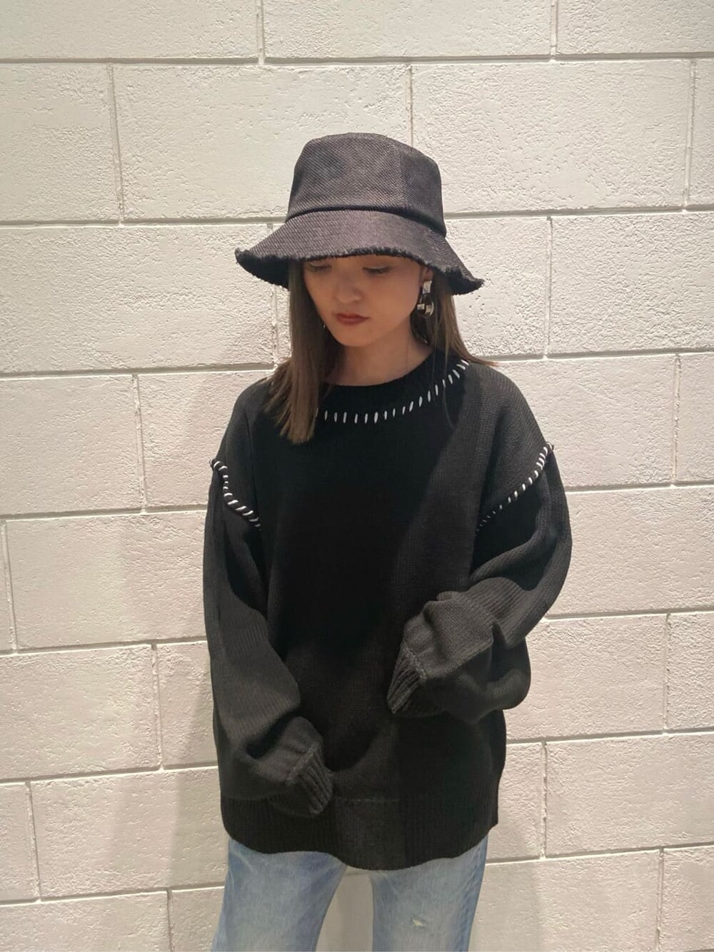 ブラック系のローファー、ブルー系のデニムパンツ、ブラック系のニット/セーターを着用したレディースの冬コーディネートの5枚目の写真