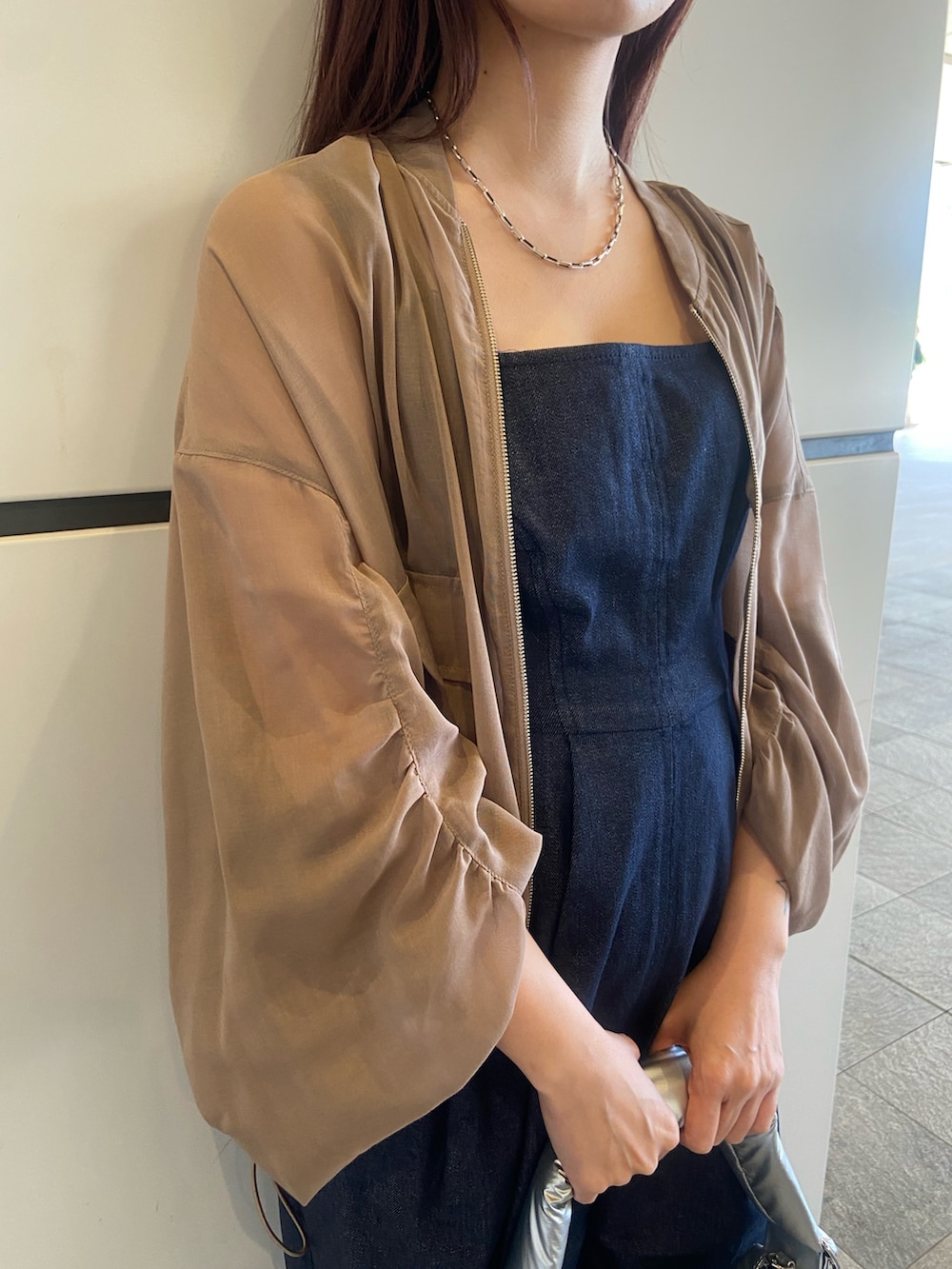 ベージュ系のブルゾン、シルバー系のハンドバッグ、ブラック系のサンダルを着用したレディースの春コーディネートの4枚目の写真