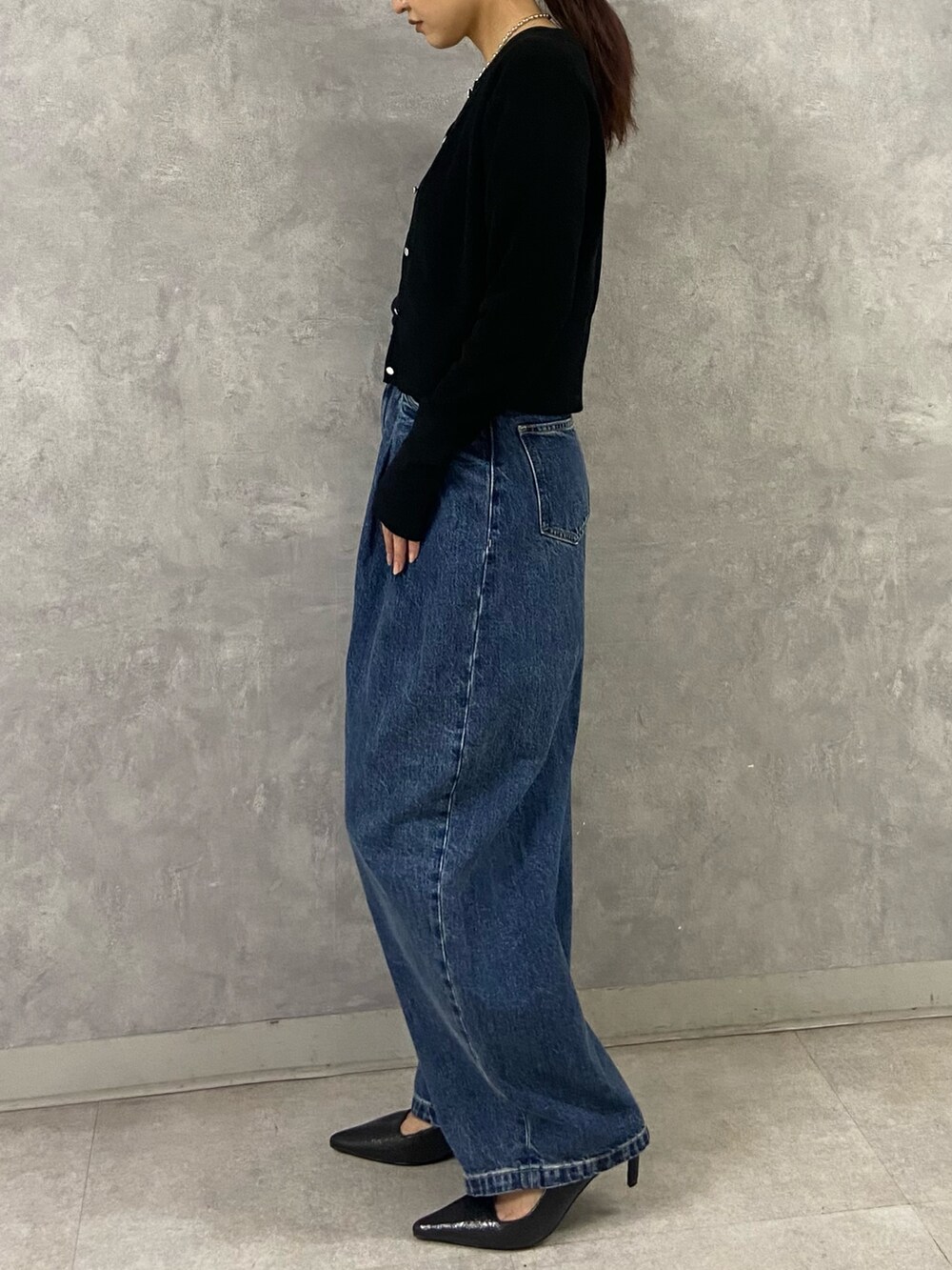 ブラック系のカーディガン/ボレロ、ブルー系のデニムパンツ、ブラック系のサンダルを着用したレディースの春コーディネートの2枚目の写真