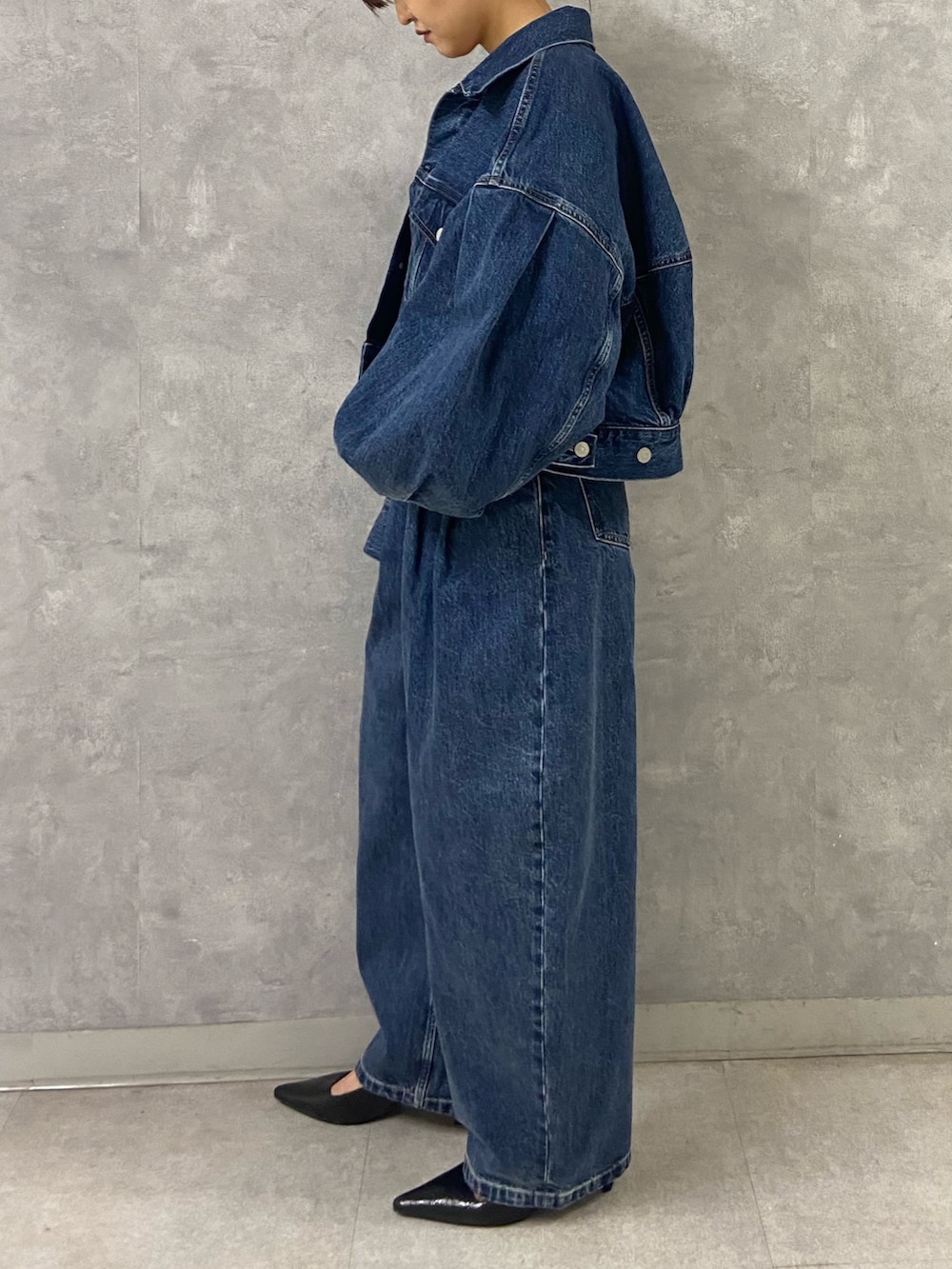 ブルー系のデニムジャケット、シルバー系のキャミソール、ブルー系のデニムパンツを着用したレディースの春コーディネートの3枚目の写真