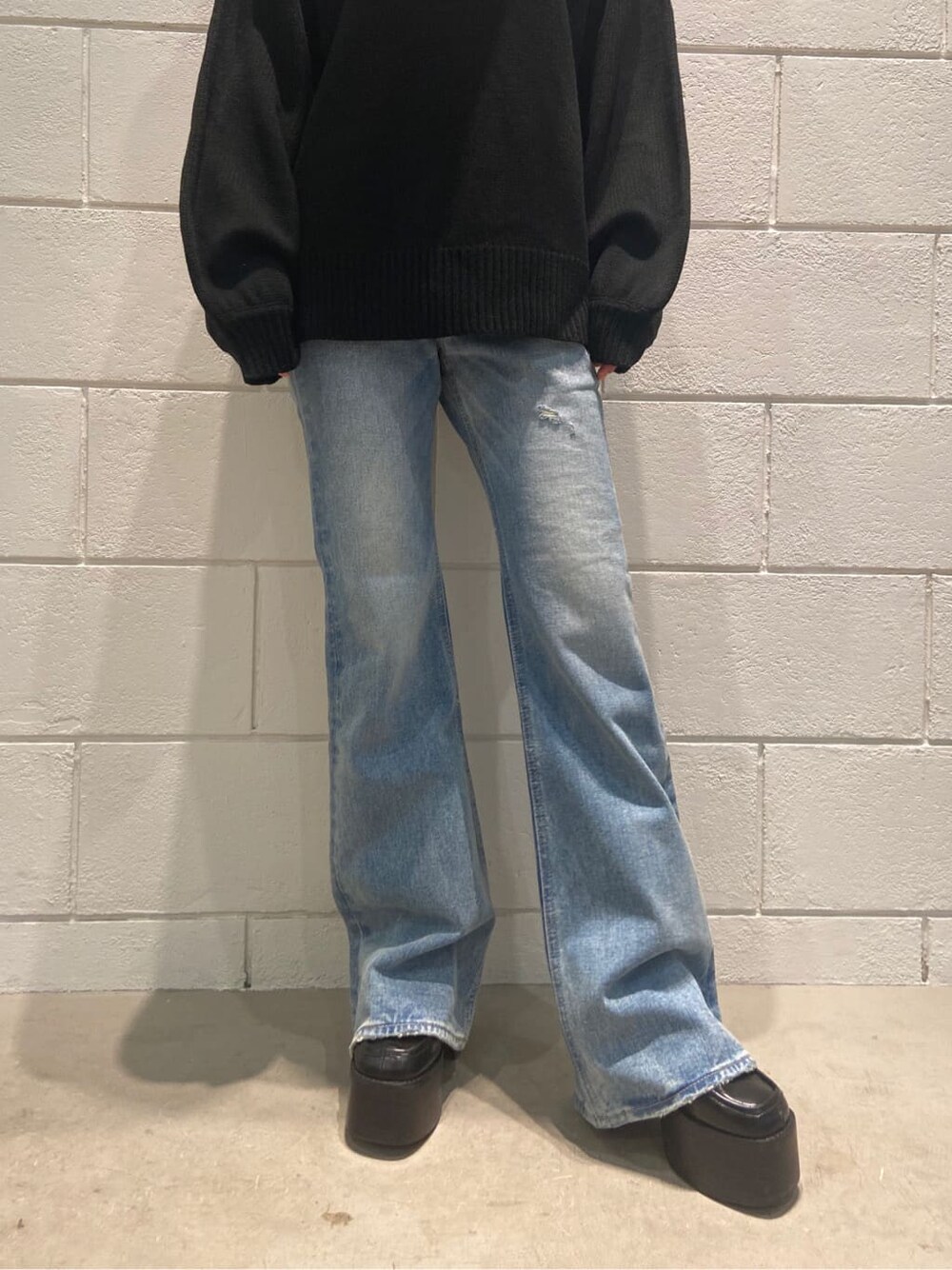 ブラック系のローファー、ブルー系のデニムパンツ、ブラック系のニット/セーターを着用したレディースの冬コーディネートの3枚目の写真