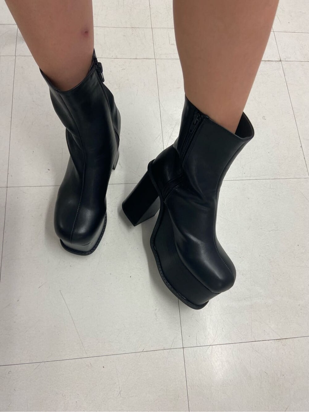 ブラック系のブーツ、ブラック系のハンドバッグ、ホワイト系のカーディガン/ボレロを着用したレディースの秋コーディネートの7枚目の写真