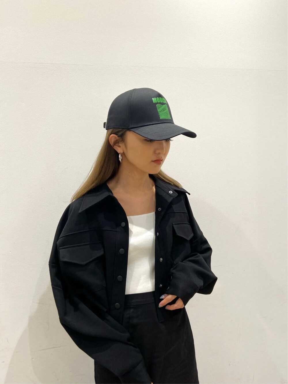 ブラック系のブルゾン、ホワイト系のサンダル、ブラック系のスカートを着用したレディースの春コーディネートの4枚目の写真