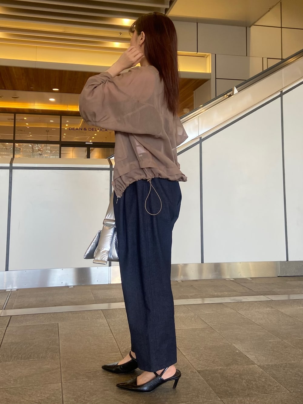 ベージュ系のブルゾン、シルバー系のハンドバッグ、ブラック系のサンダルを着用したレディースの春コーディネートの2枚目の写真