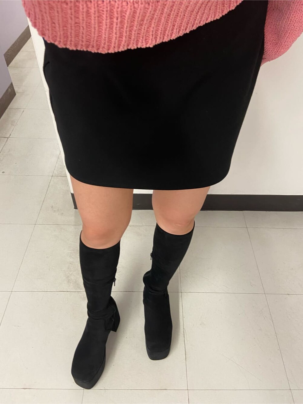 ブラック系のブーツ、ブラック系のスカート、ピンク系のニット/セーターを着用したレディースの秋コーディネートの6枚目の写真