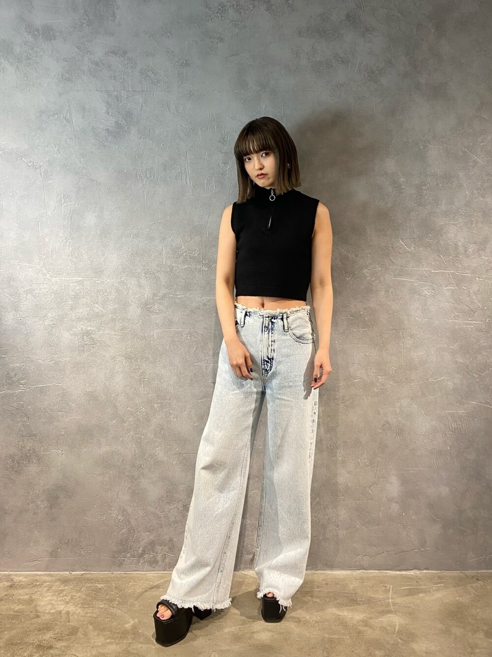 ブルー系のデニムパンツ、ブラック系のサンダルを着用したレディースの春コーディネートの2枚目の写真