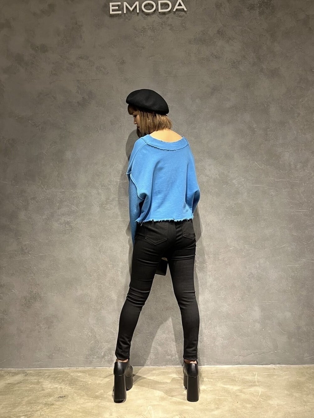 ブラック系のデニムパンツ、ブラック系のハンドバッグ、ブルー系のカーディガン/ボレロを着用したレディースの秋コーディネートの3枚目の写真