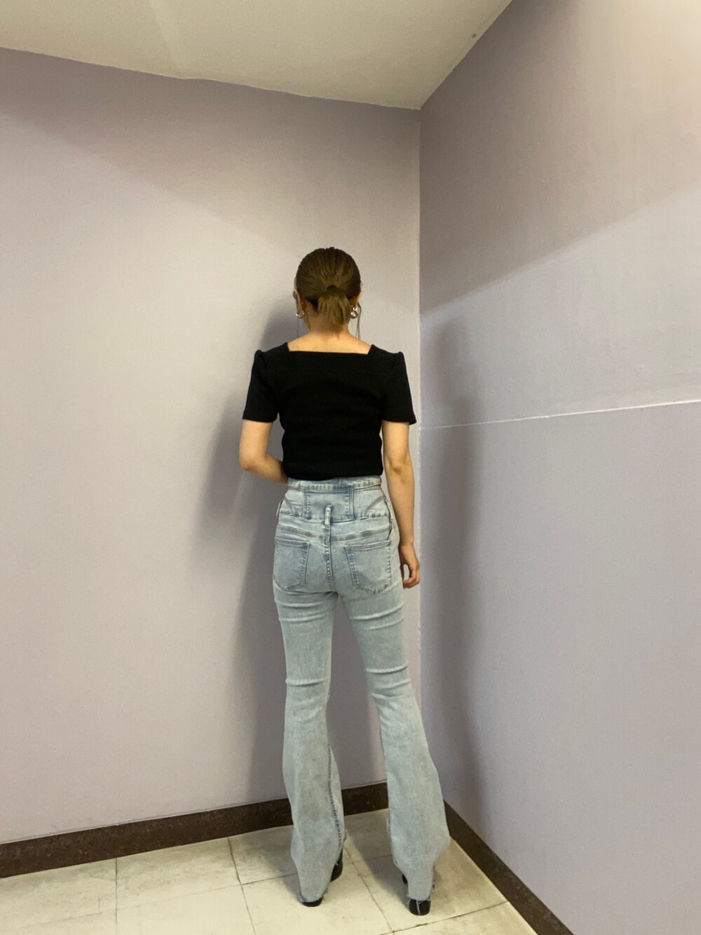 ブラック系のTシャツ/カットソー、ブルー系のデニムパンツ、ブラック系のサンダルを着用したレディースの春コーディネートの3枚目の写真