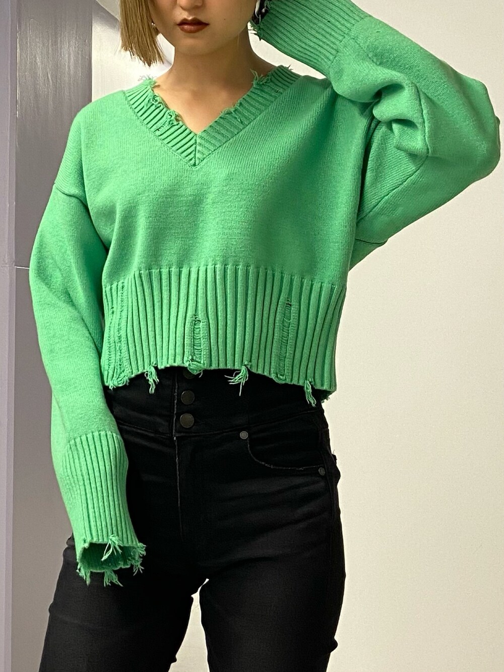 ブラック系のパンツ、グリーン系のニット/セーター、ブラック系のブーツを着用したレディースの冬コーディネートの5枚目の写真