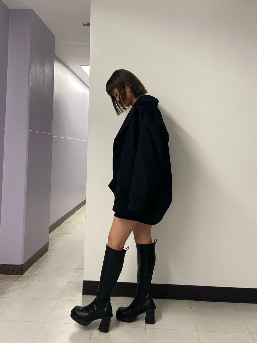 ブラック系のブーツ、ブラック系のスカート、ブラック系のテーラードジャケットを着用したレディースの秋コーディネートの2枚目の写真