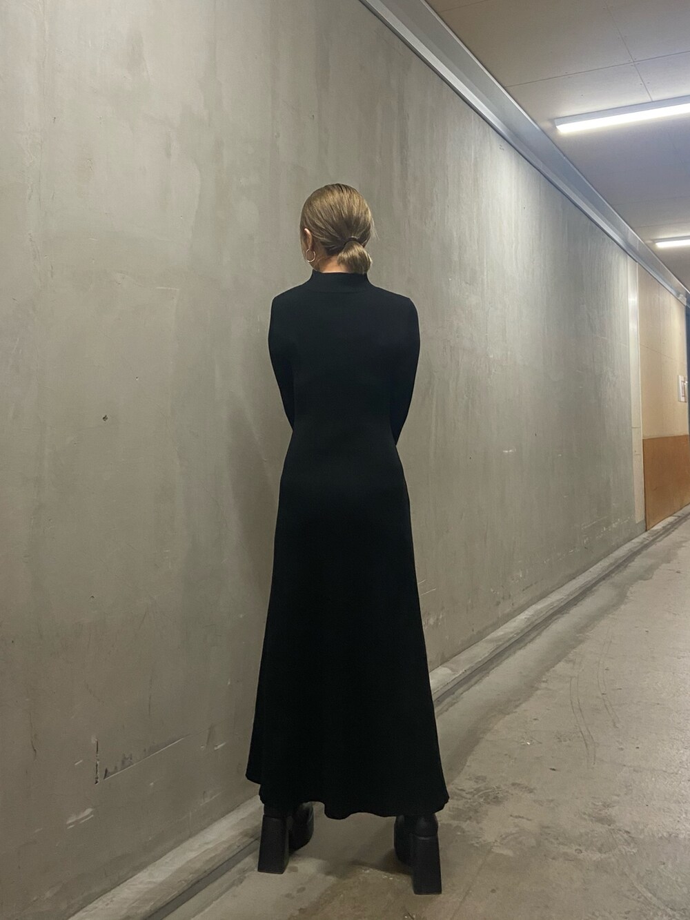 ブラック系のワンピース、ブラック系のブーツを着用したレディースの冬コーディネートの4枚目の写真