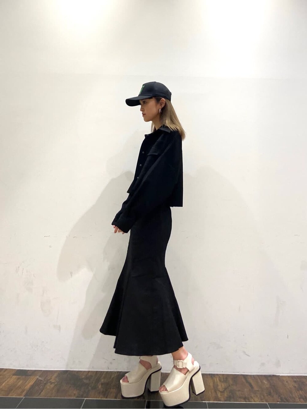 ブラック系のブルゾン、ホワイト系のサンダル、ブラック系のスカートを着用したレディースの春コーディネートの2枚目の写真