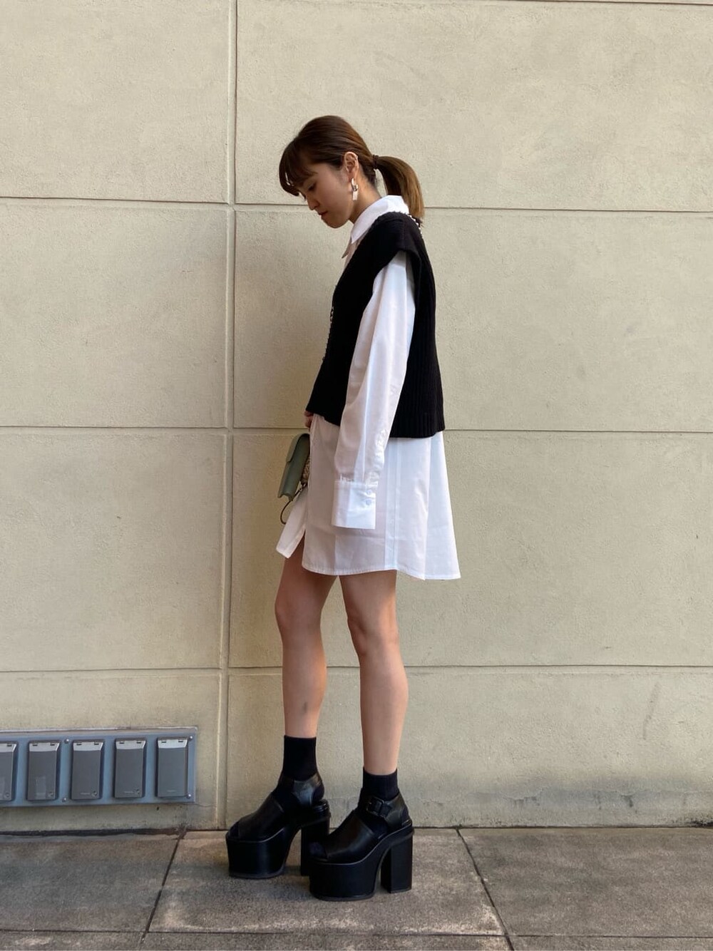 ホワイト系のシャツ/ブラウス、ブラック系のベスト、ブラック系のサンダルを着用したレディースの春コーディネートの2枚目の写真