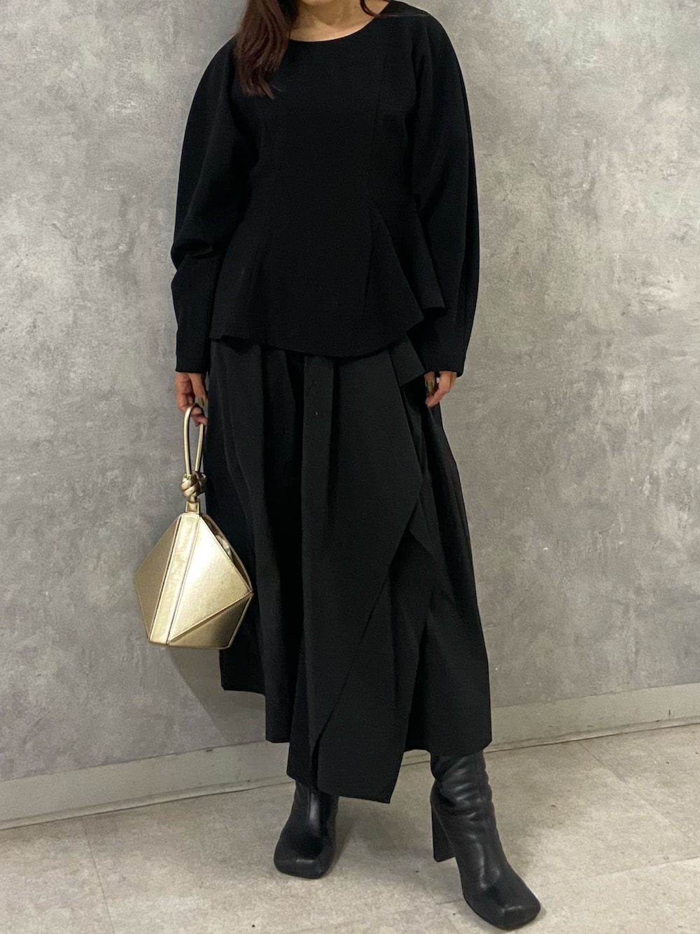 ホワイト系のブルゾン、ブラック系のワンピース、ブラック系のブーツを着用したレディースの冬コーディネートの9枚目の写真