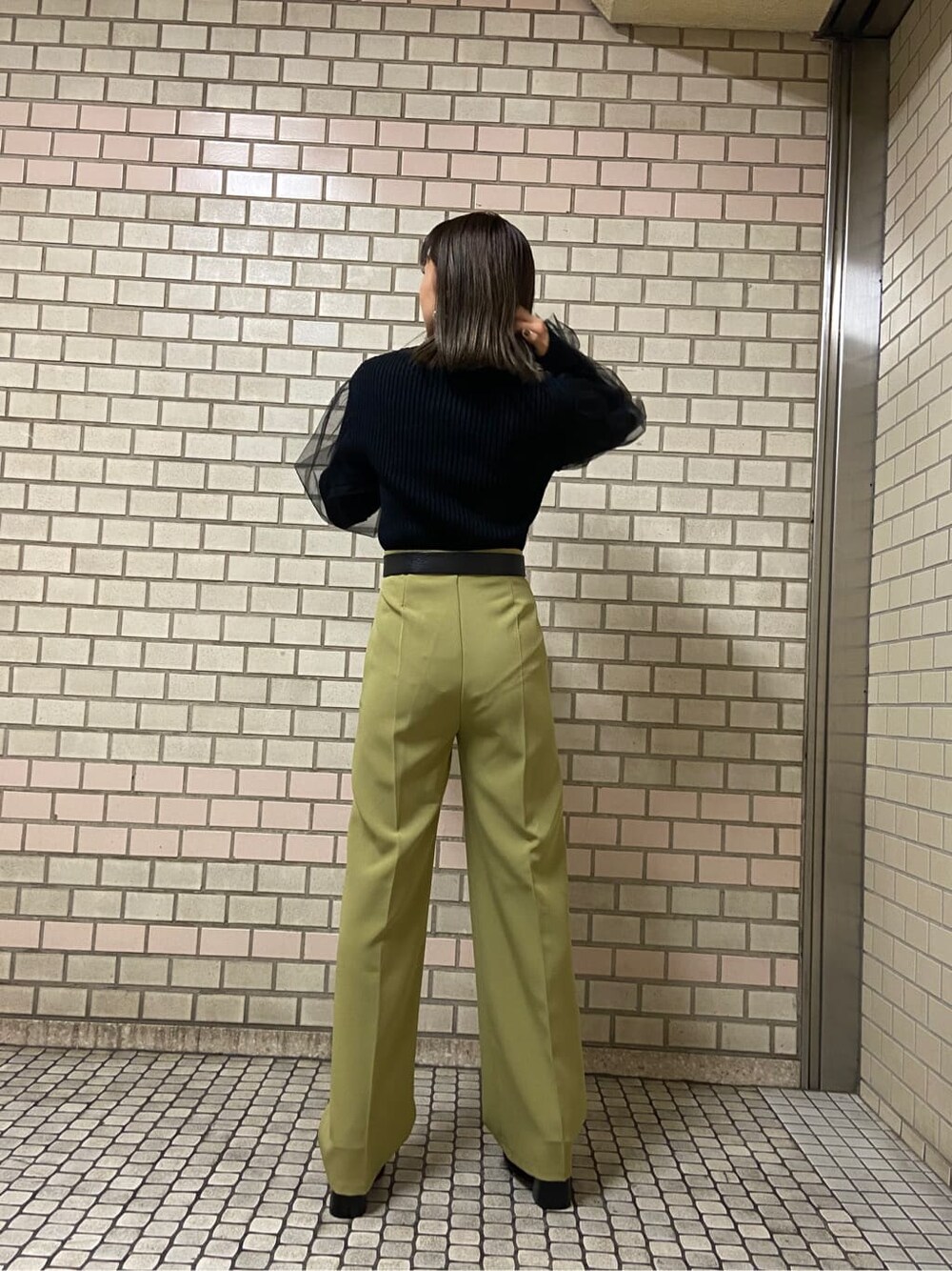 イエロー系のその他パンツ、ブラック系のローファー、ブラック系のニット/セーターを着用したレディースの秋コーディネートの3枚目の写真