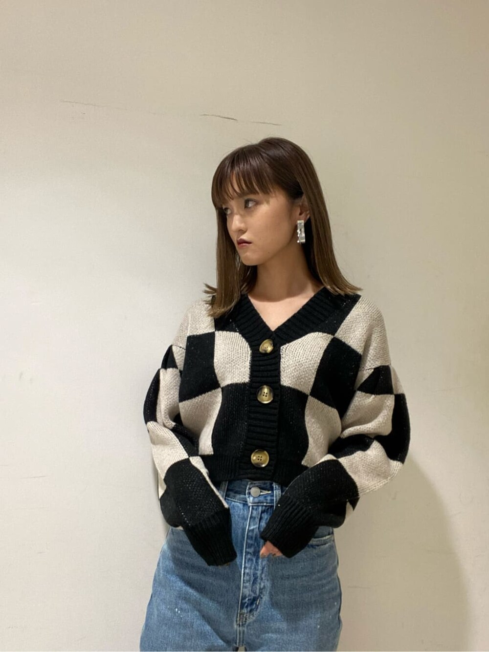 ブラック系のカーディガン/ボレロ、ブルー系のデニムパンツ、ブラック系のローファーを着用したレディースの冬コーディネートの2枚目の写真