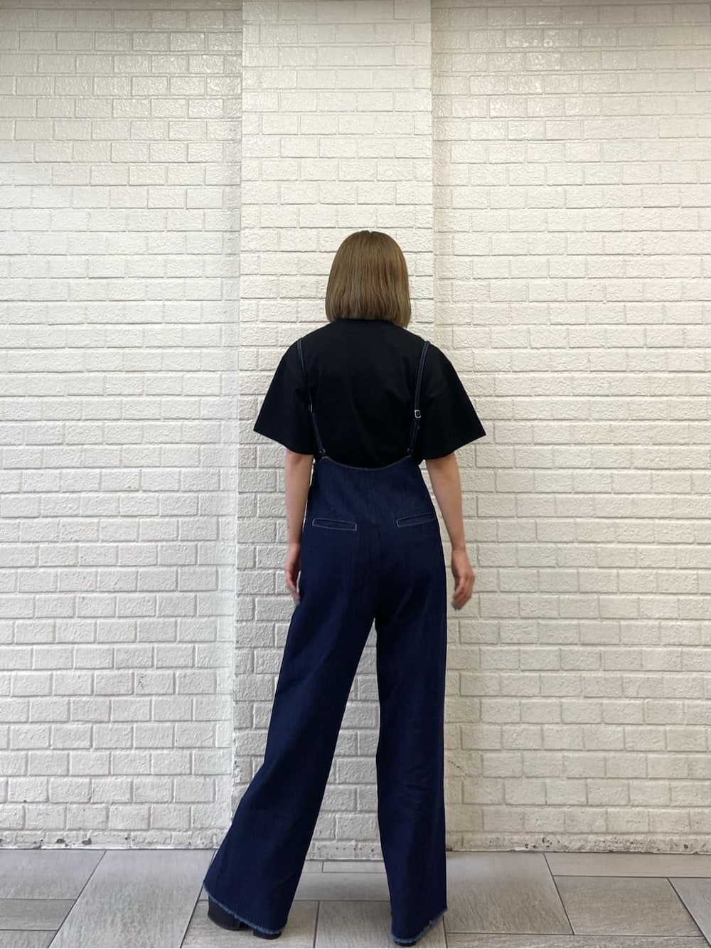 ブラック系のサンダル、ブルー系のサロペット/オーバーオール、ブラック系のTシャツ/カットソーを着用したレディースの夏コーディネートの2枚目の写真