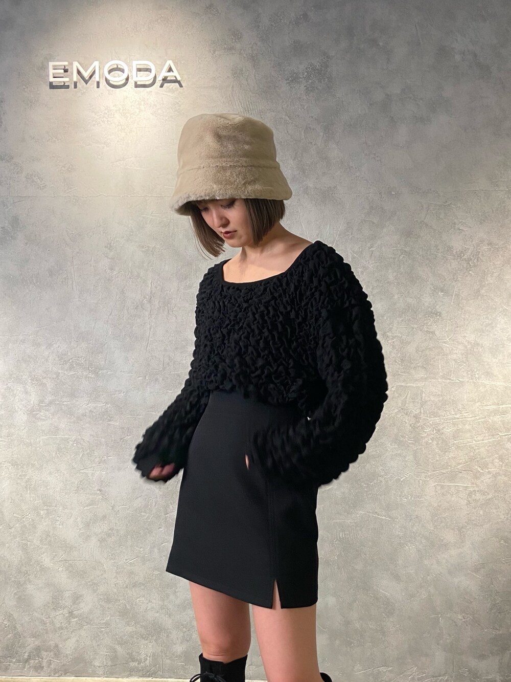 ブラック系のTシャツ/カットソー、ブラック系のスカート、ブラック系のブーツを着用したレディースの冬コーディネートの5枚目の写真