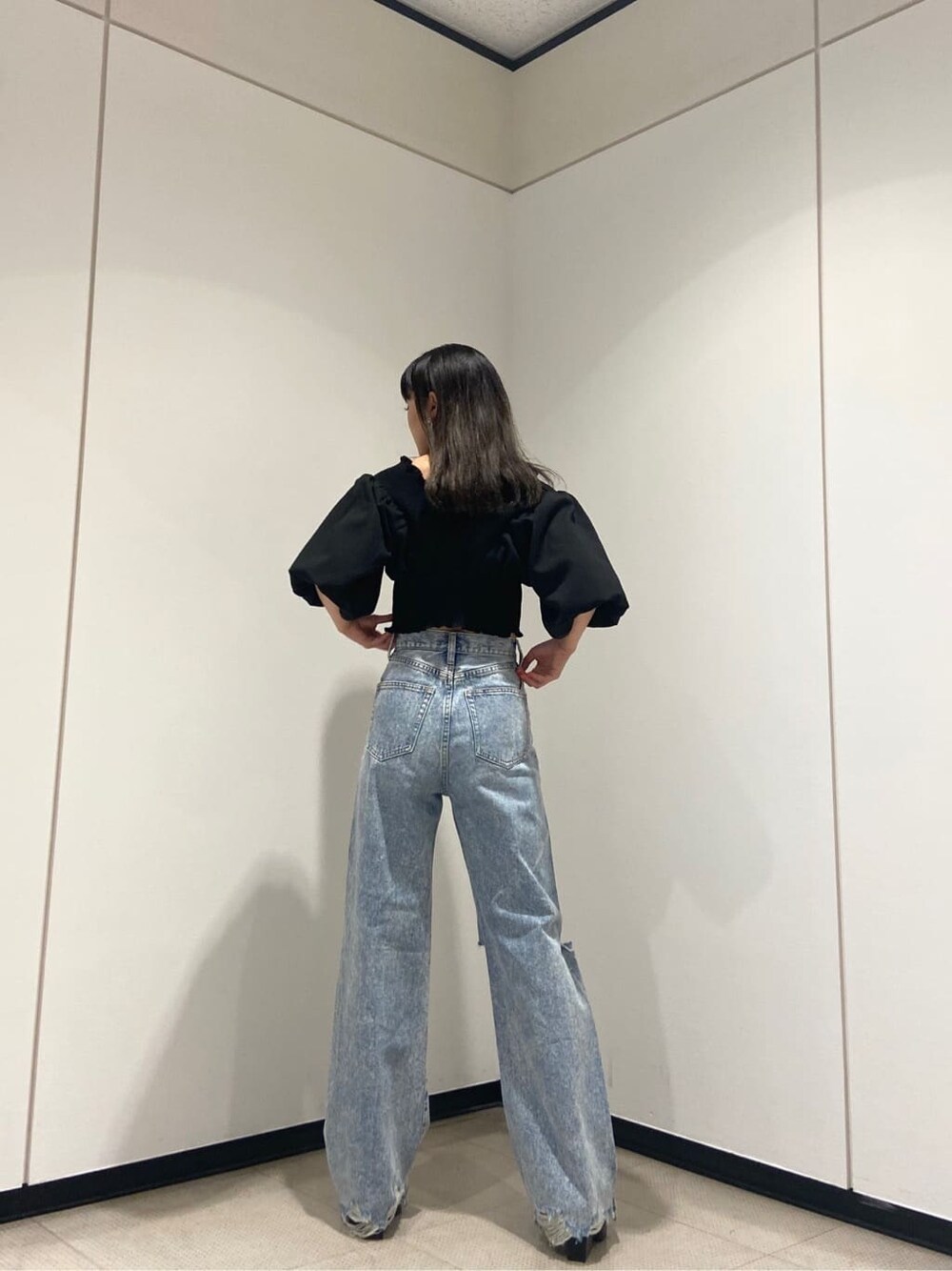 ブラック系のシャツ/ブラウス、ブラック系のサンダル、ブルー系のデニムパンツを着用したレディースの夏コーディネートの3枚目の写真