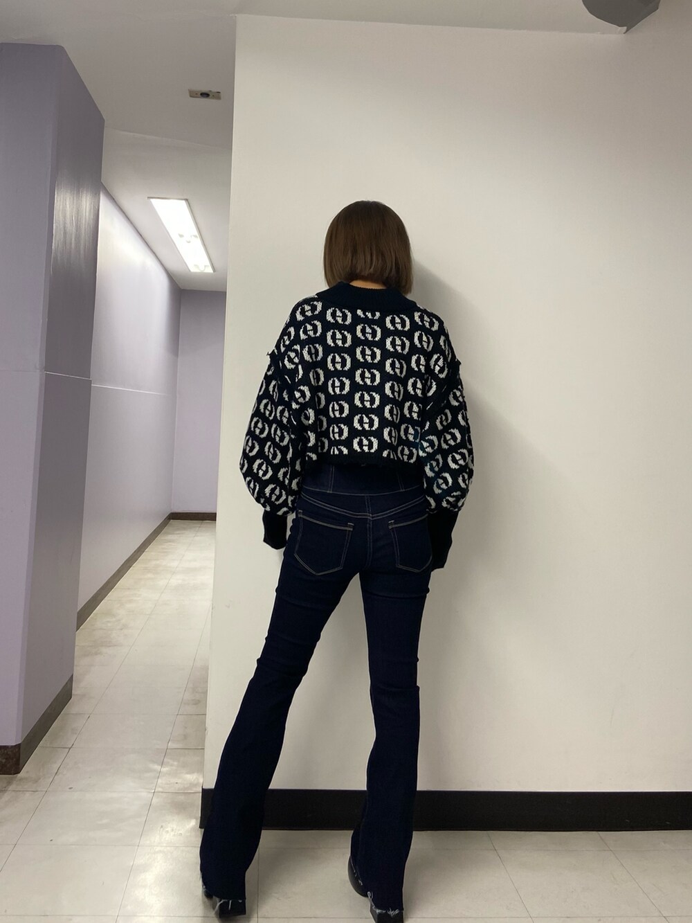 ブラック系のブーツ、ブルー系のデニムパンツ、その他のニット/セーターを着用したレディースの秋コーディネートの4枚目の写真