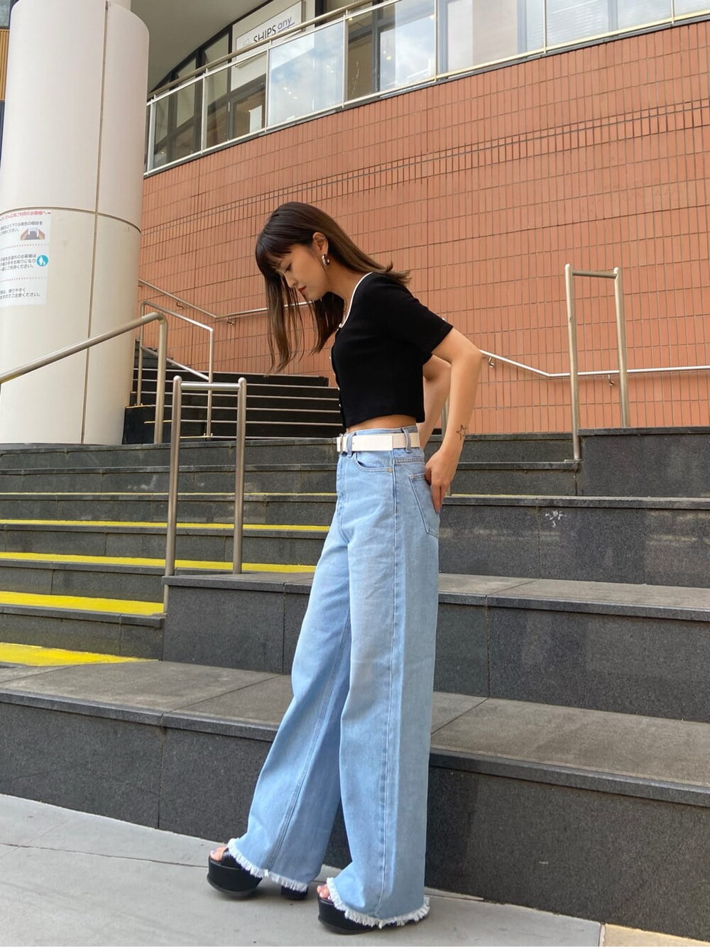 ブラック系のサンダル、ブルー系のデニムパンツ、ブラック系のTシャツ/カットソーを着用したレディースの春コーディネートの2枚目の写真