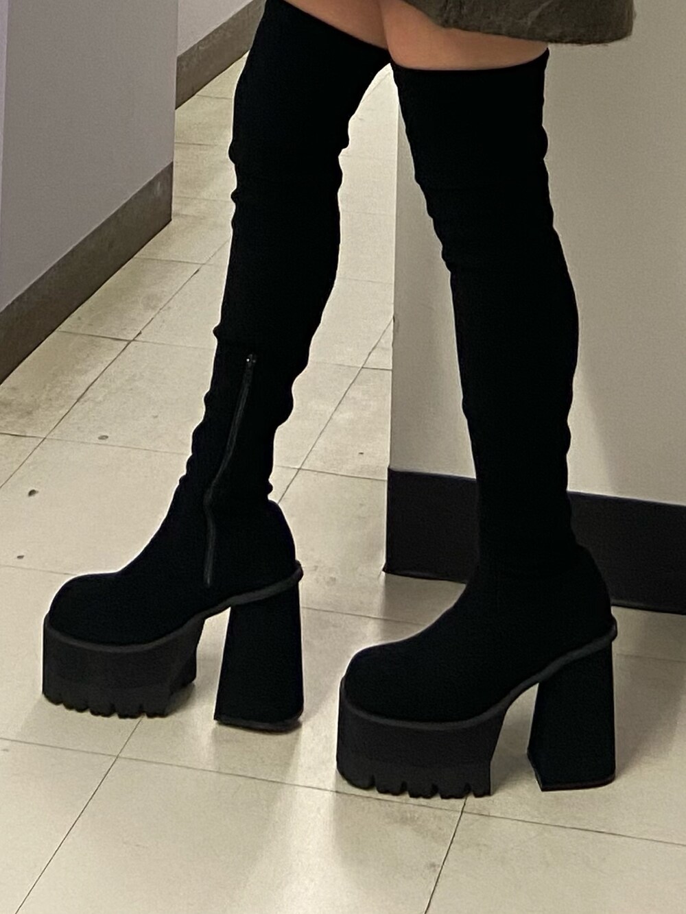 ブラック系のブーツ、ブラック系のスカート、その他のチェスターコートを着用したレディースの冬コーディネートの8枚目の写真