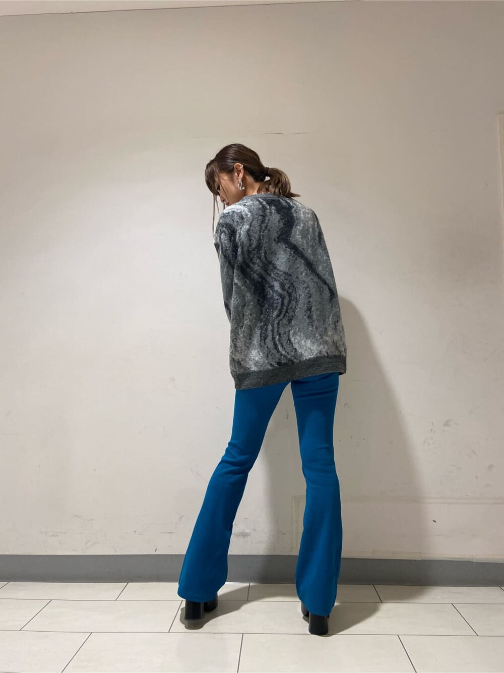 グレー系のニット/セーター、ブラック系のローファー、ブルー系のその他パンツを着用したレディースの冬コーディネートの2枚目の写真