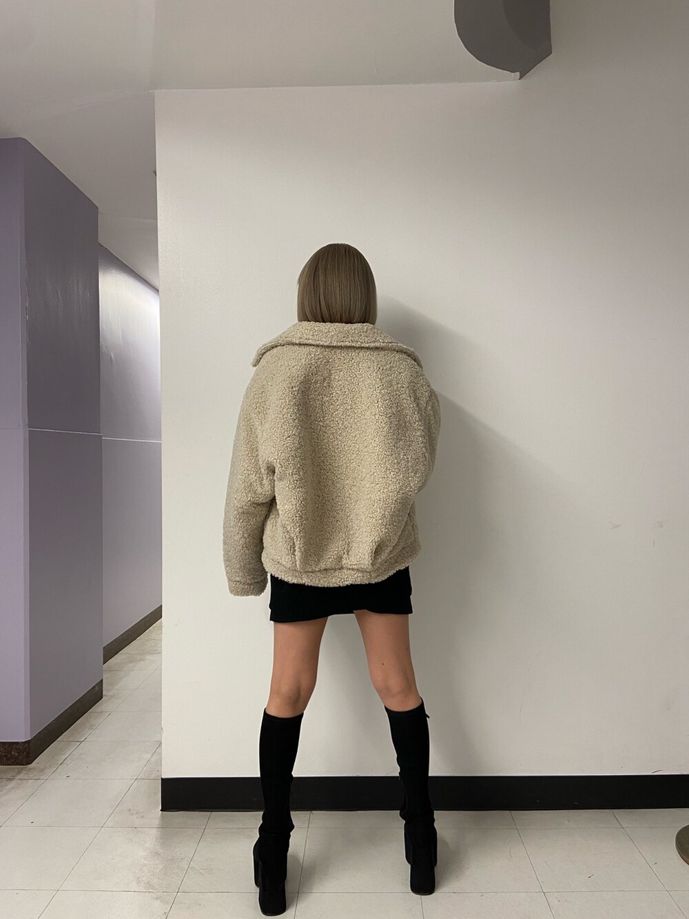 ブラック系のニット/セーター、ホワイト系のブルゾン、ブラック系のスカートを着用したレディースの冬コーディネートの4枚目の写真