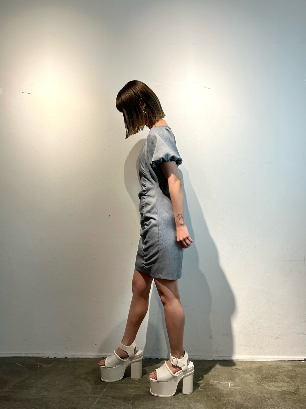 グレー系のワンピース、ホワイト系のサンダルを着用したレディースの春コーディネートの3枚目の写真