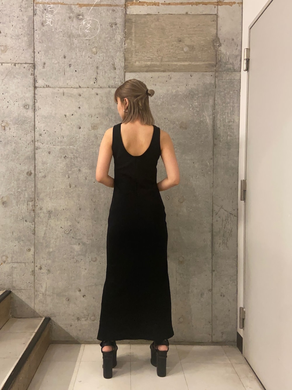 ブラック系のワンピース、パープル系のハンドバッグ、ブラック系のサンダルを着用したレディースの春コーディネートの3枚目の写真