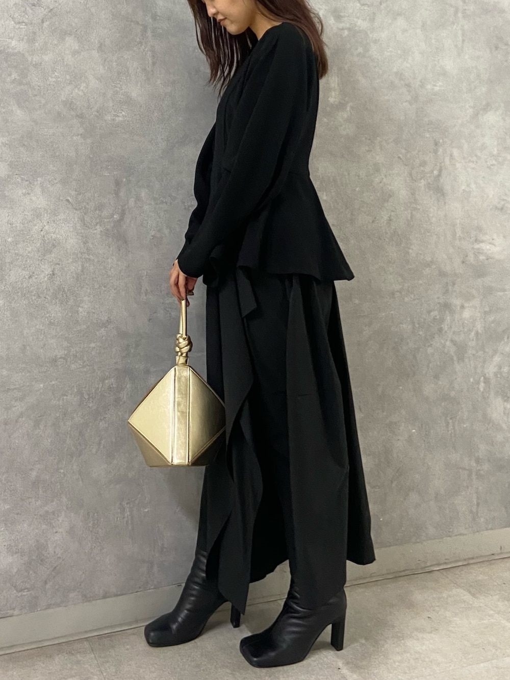 ホワイト系のブルゾン、ブラック系のワンピース、ブラック系のブーツを着用したレディースの冬コーディネートの7枚目の写真