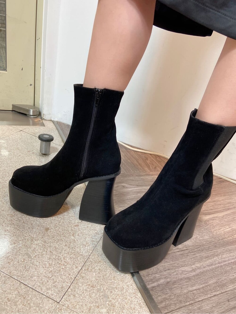 ブラック系のスカート、ブラック系のブーツ、グリーン系のニット/セーターを着用したレディースの秋コーディネートの6枚目の写真