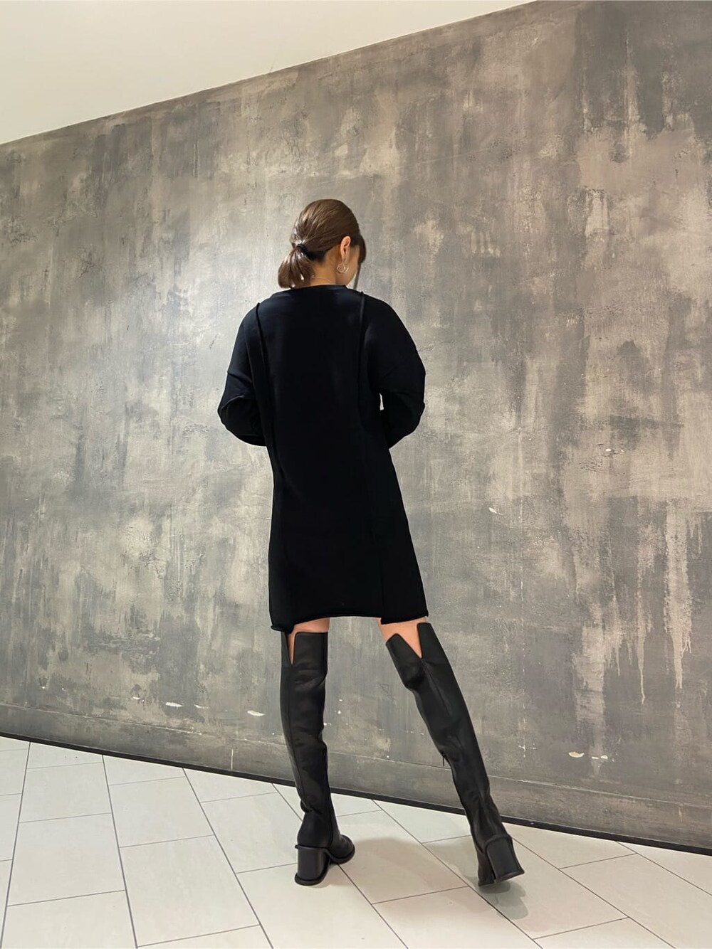 ブラック系のワンピース、ブラック系のブーツ、グリーン系のボディバッグ/ウエストポーチを着用したレディースの秋コーディネートの3枚目の写真