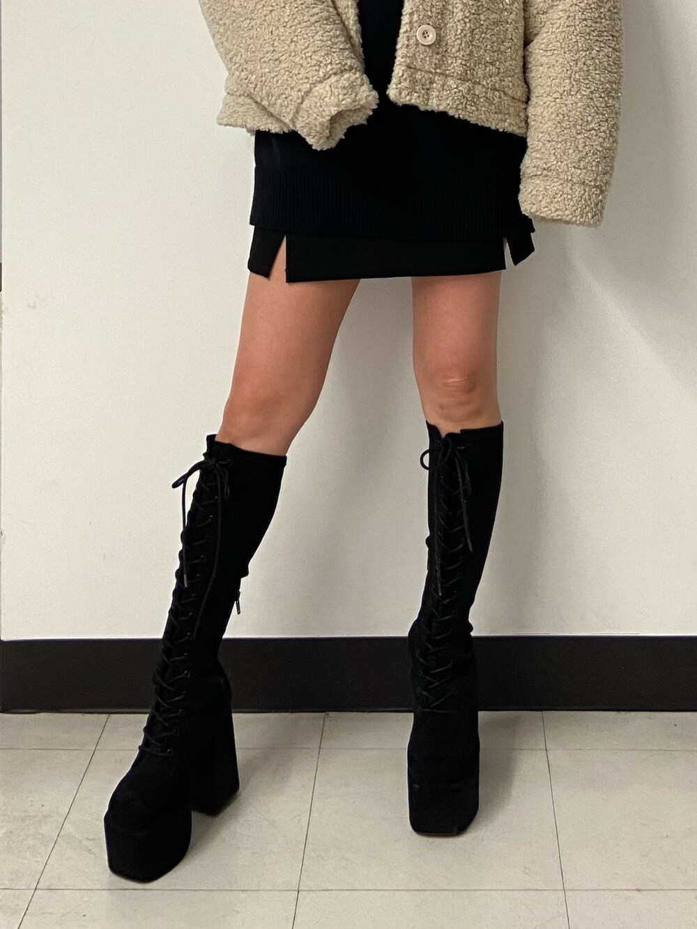 ブラック系のニット/セーター、ホワイト系のブルゾン、ブラック系のスカートを着用したレディースの冬コーディネートの6枚目の写真