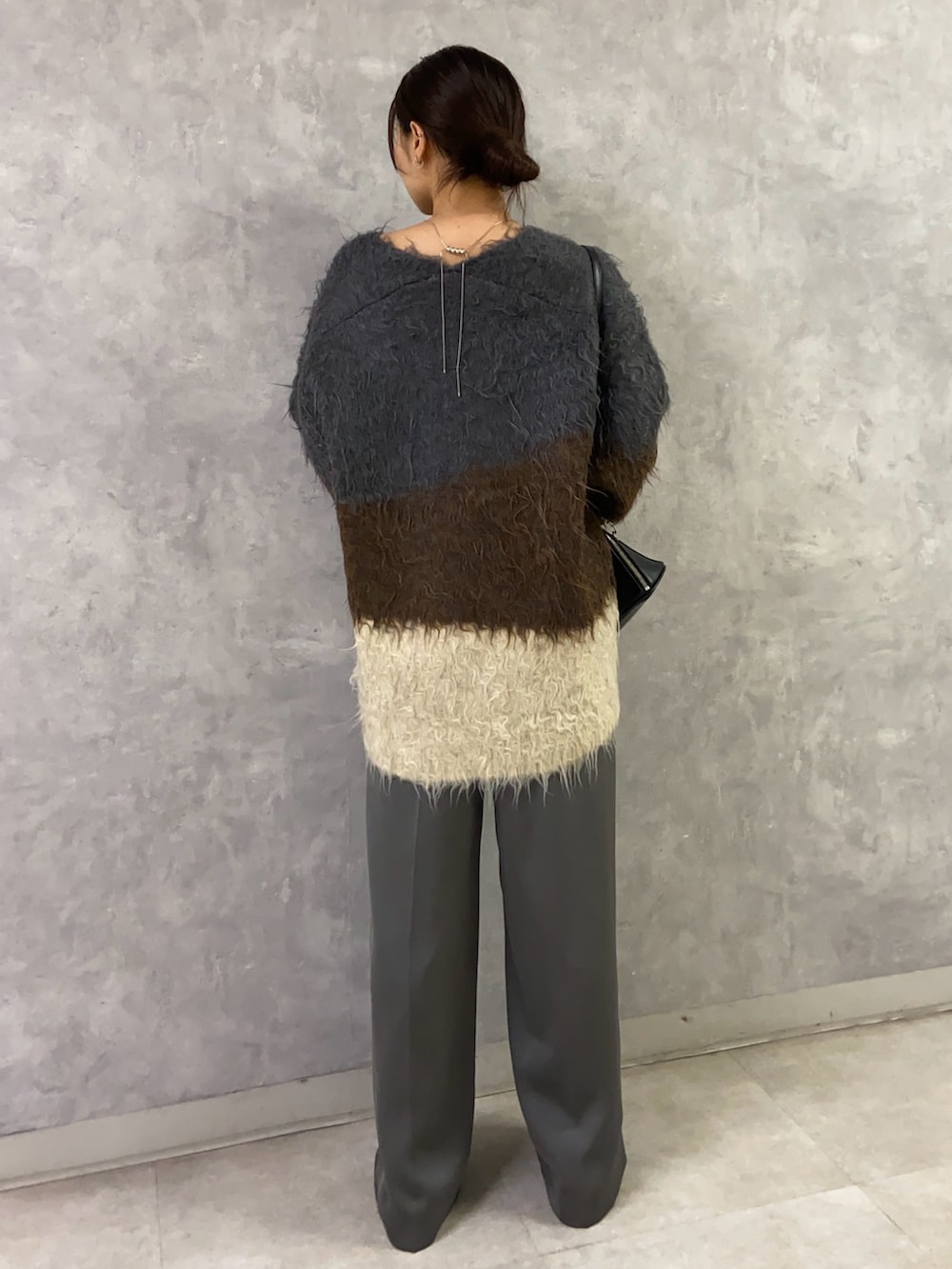 ブラウン系のニット/セーター、グレー系のその他パンツ、ホワイト系のパンプスを着用したレディースの秋コーディネートの3枚目の写真