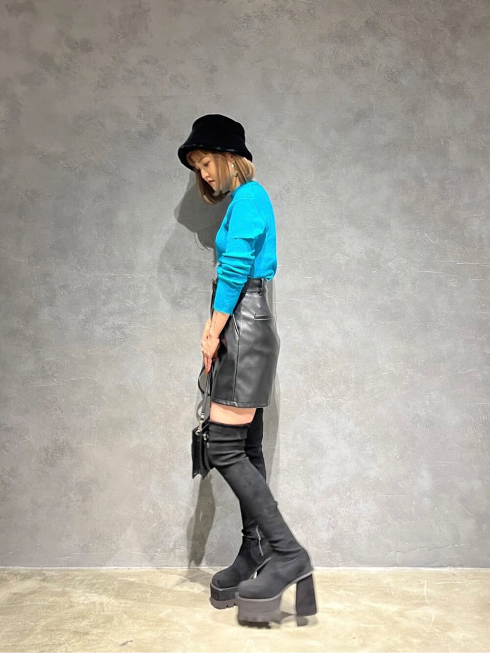 ブラック系のハンドバッグ、ブルー系のニット/セーター、ブラック系のその他パンツを着用したレディースの秋コーディネートの2枚目の写真