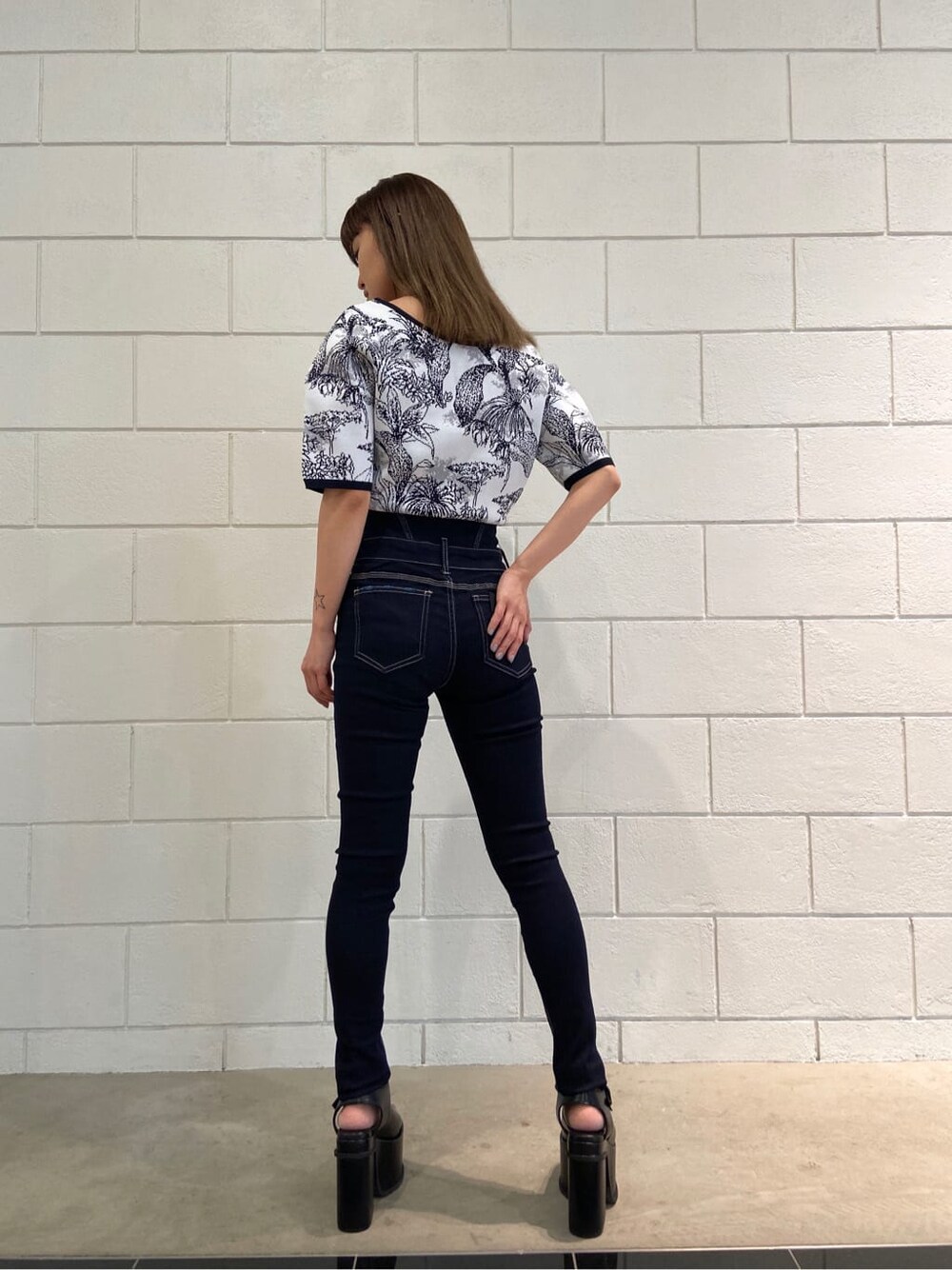 ブルー系のデニムパンツ、ブラック系のサンダル、その他のニット/セーターを着用したレディースの春コーディネートの3枚目の写真