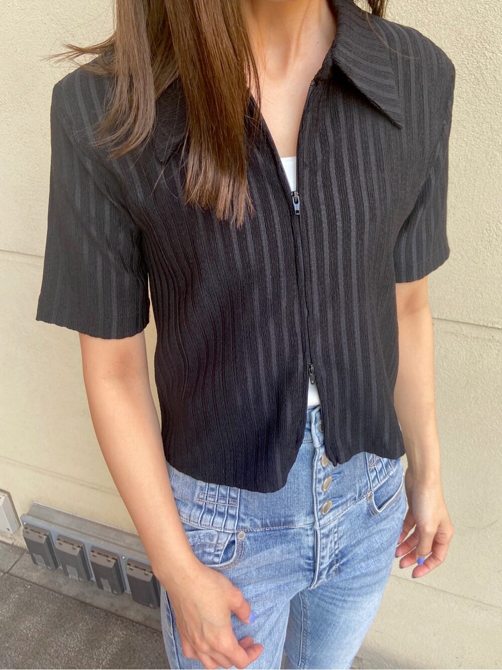 ブルー系のデニムパンツ、ホワイト系のタンクトップ、ブラック系のサンダルを着用したレディースの春コーディネートの6枚目の写真