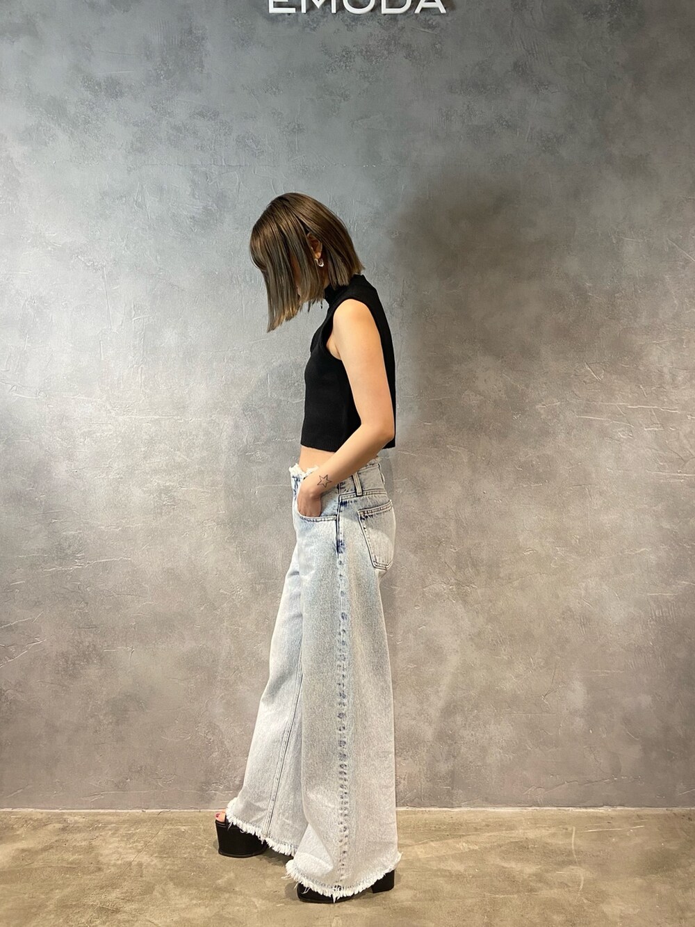 ブルー系のデニムパンツ、ブラック系のサンダルを着用したレディースの春コーディネートの3枚目の写真