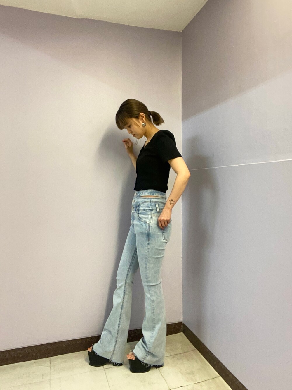 ブラック系のTシャツ/カットソー、ブルー系のデニムパンツ、ブラック系のサンダルを着用したレディースの春コーディネートの2枚目の写真