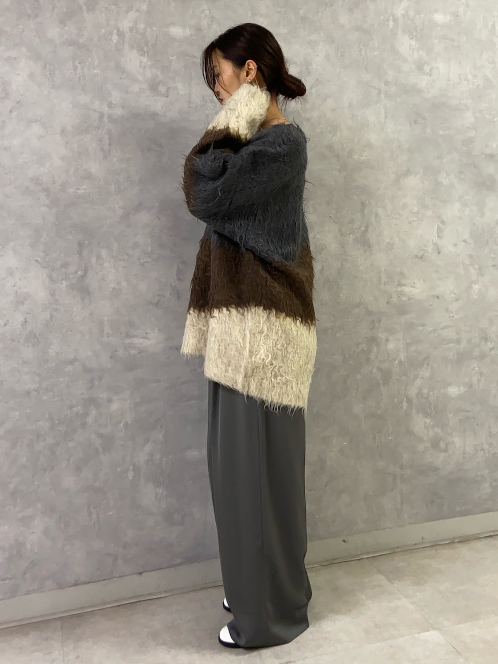 ブラウン系のニット/セーター、グレー系のその他パンツ、ホワイト系のパンプスを着用したレディースの秋コーディネートの2枚目の写真