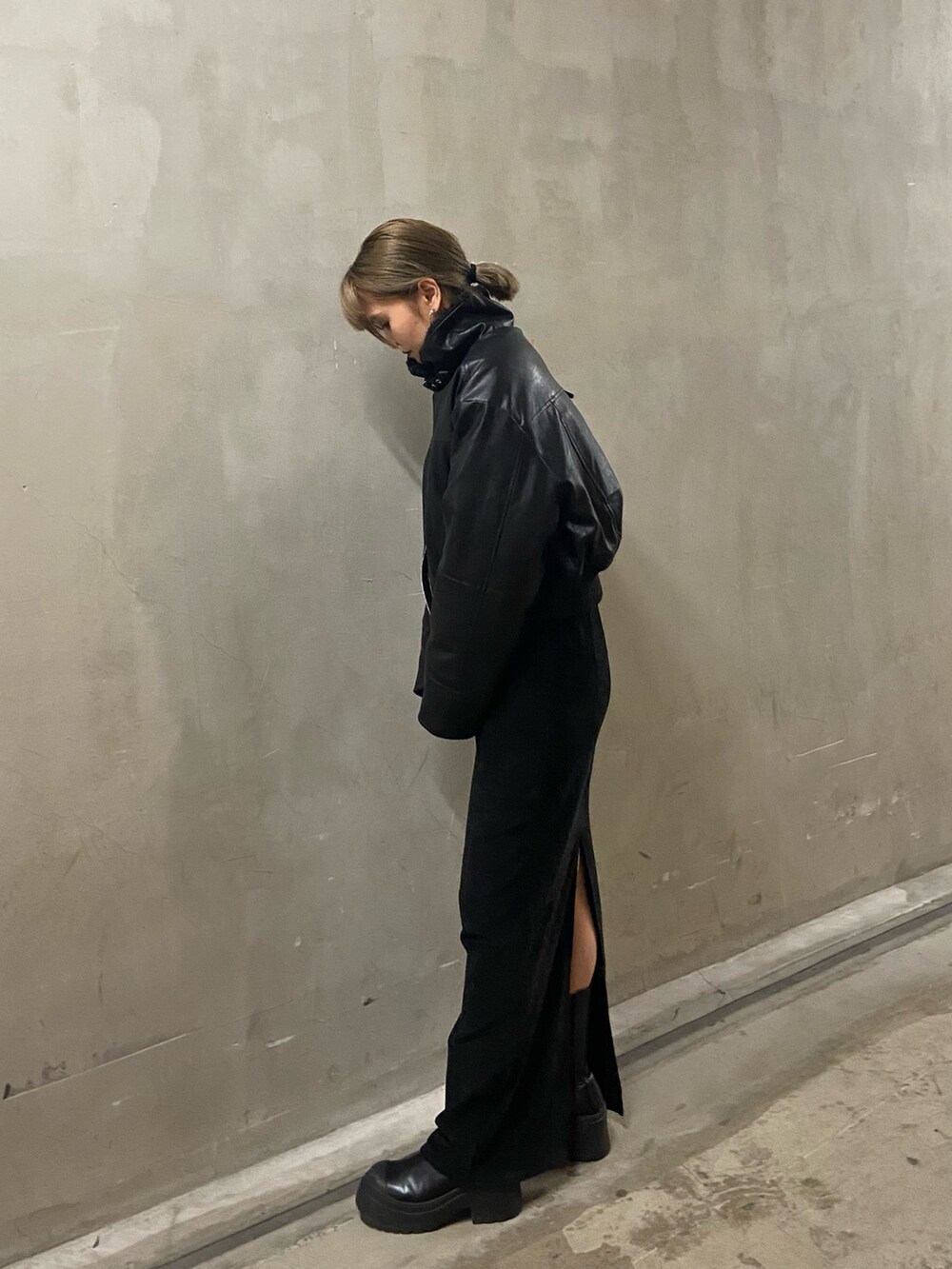 ブラック系のブルゾン、ブラック系のスカート、ブラック系のブーツを着用したレディースの秋コーディネートの3枚目の写真