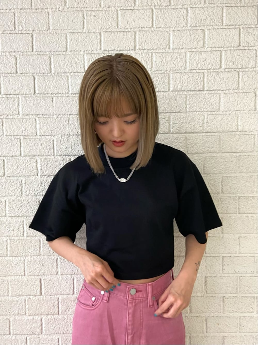 ピンク系のデニムパンツ、ブラック系のサンダル、ブラック系のTシャツ/カットソーを着用したレディースの夏コーディネートの4枚目の写真