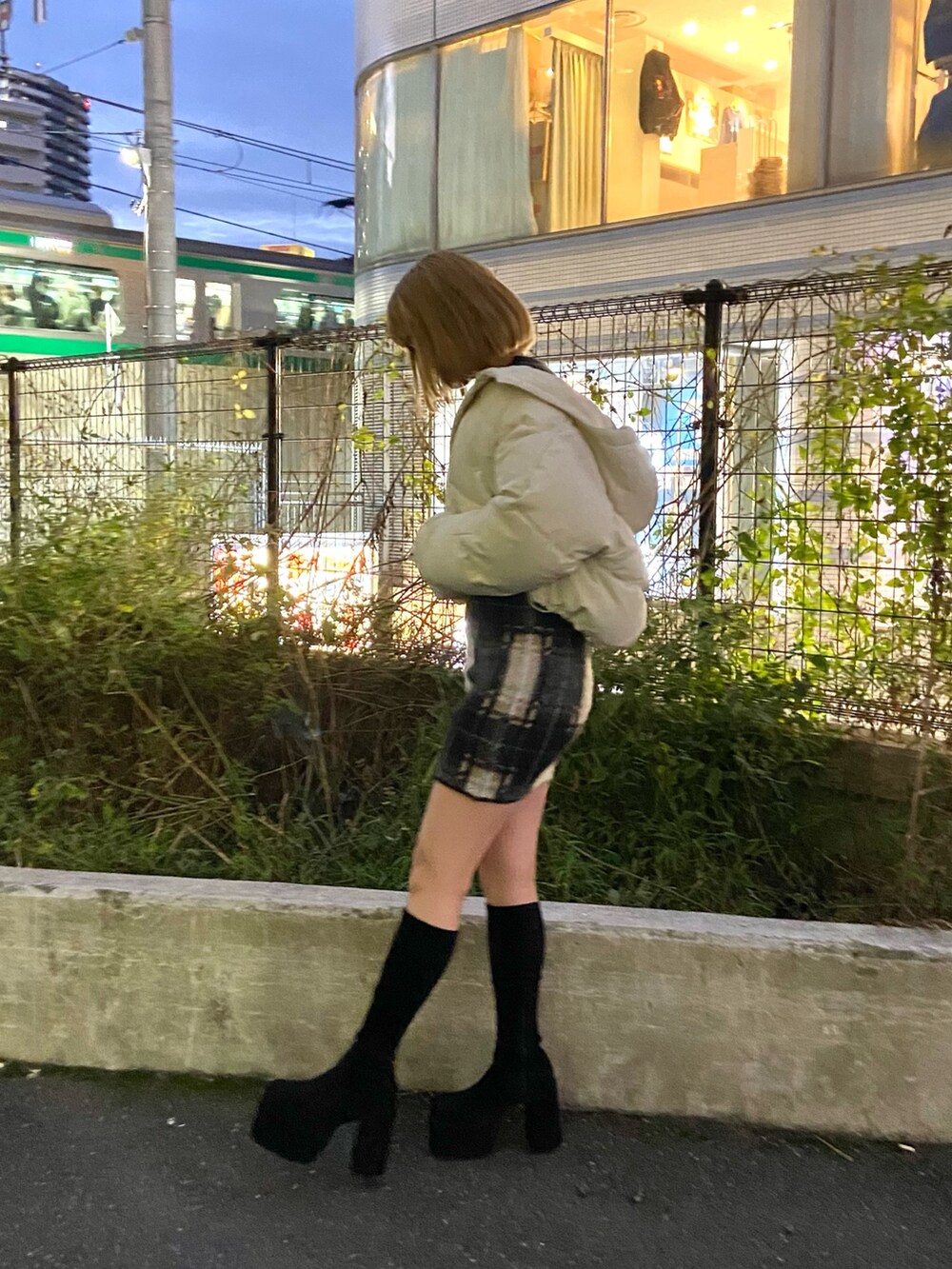 ホワイト系のダウンジャケット/コート、ブラック系のニット/セーター、ブラック系のスカートを着用したレディースの冬コーディネートの3枚目の写真