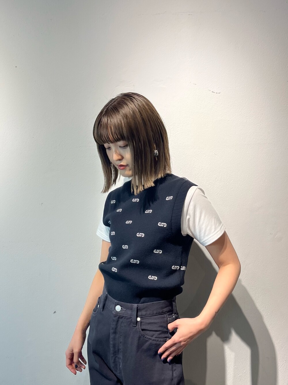 ホワイト系のTシャツ/カットソー、ブラック系のデニムパンツ、ホワイト系のサンダルを着用したレディースの春コーディネートの5枚目の写真