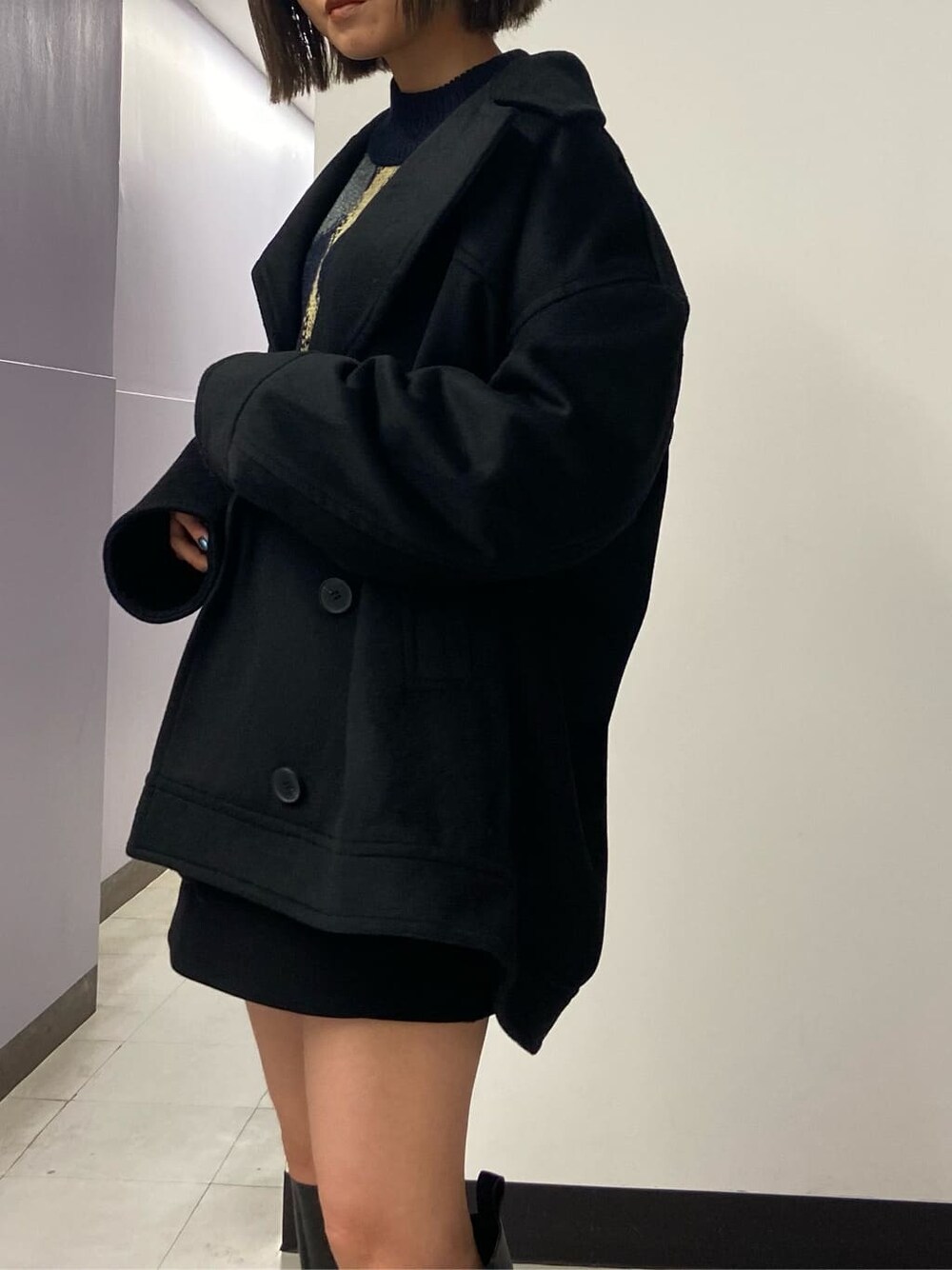 ブラック系のブーツ、ブラック系のスカート、ブラック系のテーラードジャケットを着用したレディースの秋コーディネートの4枚目の写真