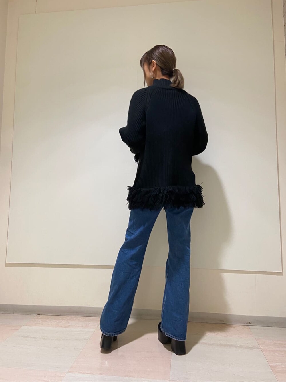 ブラック系のブーツ、ブルー系のデニムパンツ、ブラック系のニット/セーターを着用したレディースの冬コーディネートの2枚目の写真