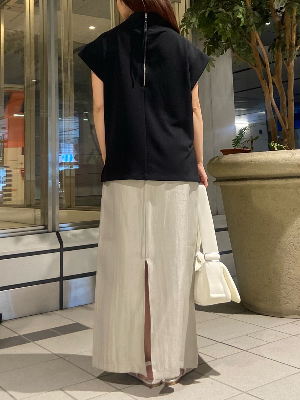 ブラック系のTシャツ/カットソー、ベージュ系のスカート、ホワイト系のサンダルを着用したレディースの春コーディネートの3枚目の写真