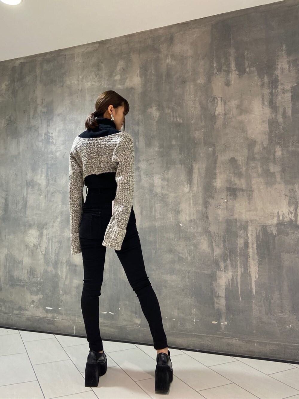 ブラック系のローファー、ブラック系のニット/セーター、ブラック系のデニムパンツを着用したレディースの秋コーディネートの5枚目の写真