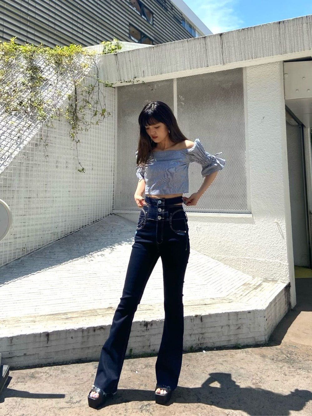 ブラック系のサンダル、ブルー系のデニムパンツ、グレー系のシャツ/ブラウスを着用したレディースの夏コーディネートの2枚目の写真